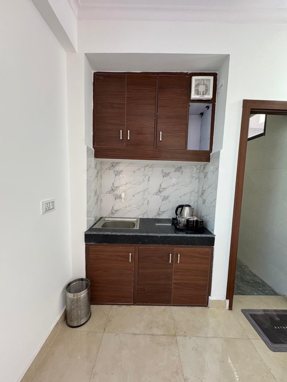 Modular in-room kitchen and pantry setup with storage cabinets at The Sukoon Stays